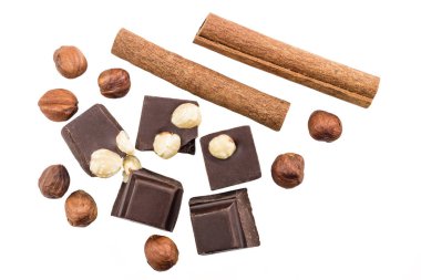 Fındıklı ve tarçınlı acı siyah çikolata parçaları beyaz arka planda izole edilmiş..