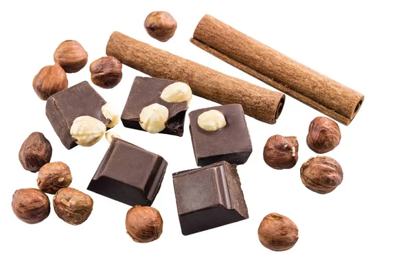 Fındıklı ve tarçınlı acı siyah çikolata parçaları beyaz arka planda izole edilmiş..