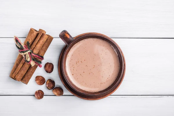 Gorące Kakao Mlekiem Brązowej Glinianej Filiżance Orzech Laskowy Cynamonowe Patyczki — Zdjęcie stockowe