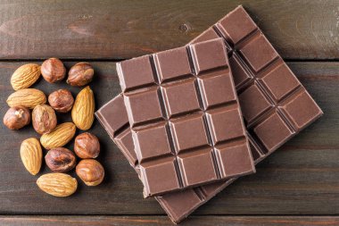 Acı, koyu çikolata, badem ve fındık ahşap arka plan üzerinde ana sayfa görünümü.