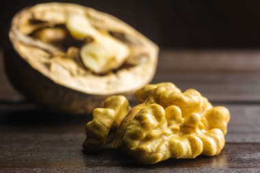 Yarım ceviz çekirdek ve yarım ceviz kabuğu koyu ahşap arka plan üzerinde.