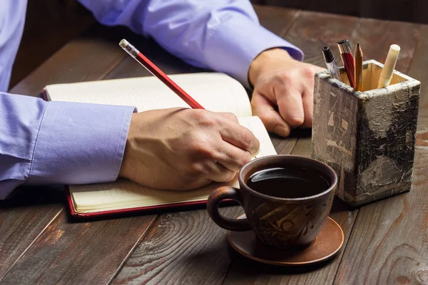 Mano Masculina Con Lápiz Rojo Escribe Bloc Notas Café Negro — Foto de Stock