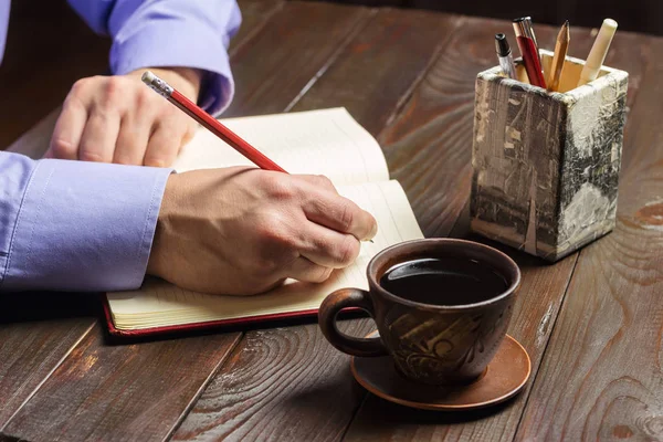 Männliche Hand Mit Rotem Bleistift Schreibt Notizblock Schwarzer Kaffee Brauner — Stockfoto