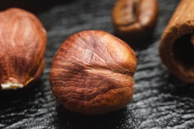 Siyah deri doku arka plan, makro görüntü üzerinde kahverengi, ham fındık çekirdek.