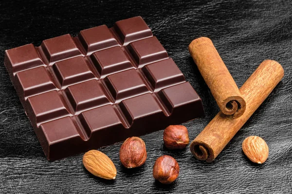 Dark Bitter Chocolate Bar Almond Nuts Hazelnut Two Cinnamon Sticks — Stock Photo, Image