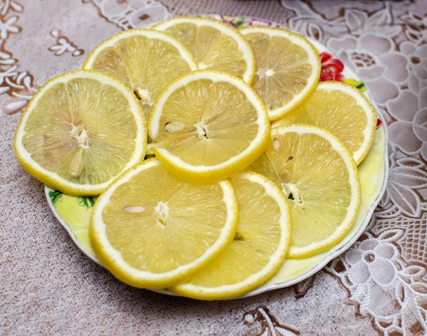 The lemon cut by segments on a dish on a white cloth. — Stock Photo, Image