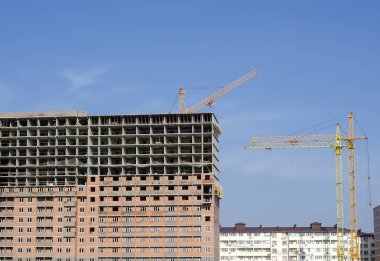 Yapım aşamasında binalar arasında üç İnşaat vinçleri.