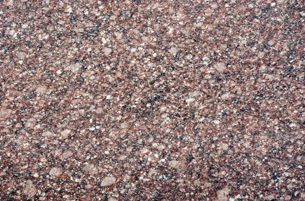 Crystal structure of gray-pink granite with white impregnations.