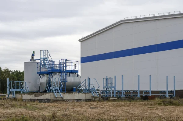 Un bâtiment industriel blanc et un bloc réservoir à proximité close-u — Photo