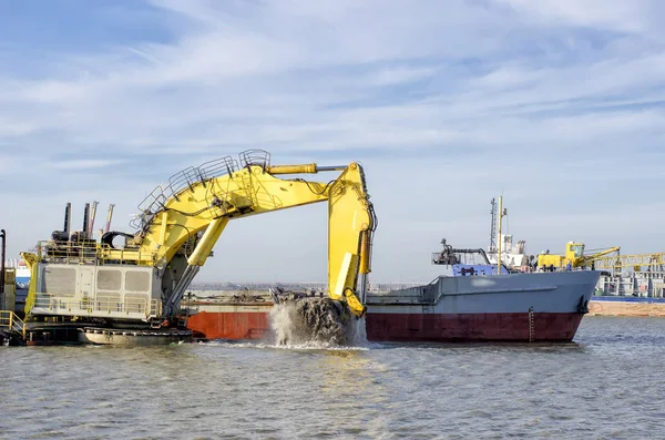 Deepening the water area of the port. A floating excavator loads — Stock Photo, Image