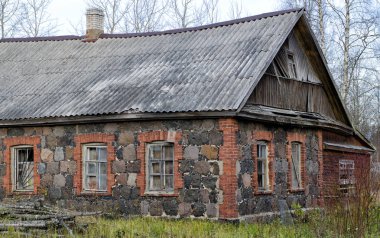 Taştan duvarları ve tahta çatısı olan eski ıssız bir ev.