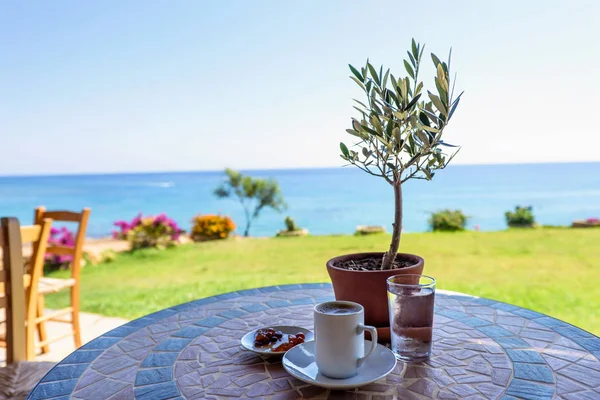 Чашка кофе на столе с оливковым деревом — стоковое фото