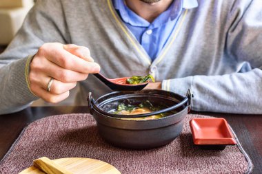 Geleneksel bir Japon restoranında bir adam yeme miso çorbası