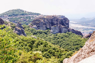 Yemyeşil ağaçlar ve kaya dağlar gün batımında