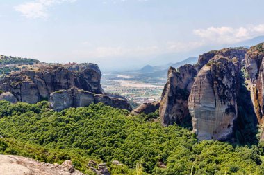 Yemyeşil ağaçlar ve kaya dağlar gün batımında
