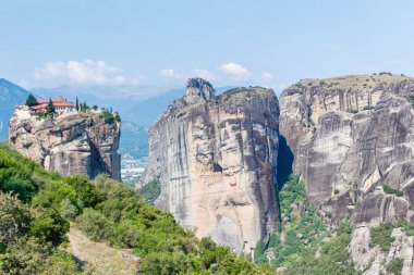 Yemyeşil ağaçlar ve kaya dağlar gün batımında