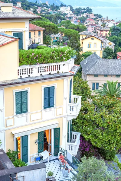 View from top to apartments balcony with people talking on chair — Stock Photo, Image