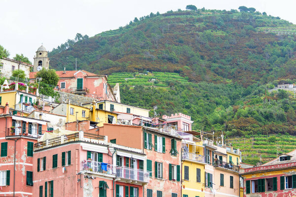 View to old houses and mountains with vineyards in Vernazza, Cinque Terre, Italy.