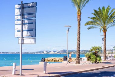 Gün ışığı güneşli görünümüne şehir, mavi deniz ve sidew üzerinde çalışan kadın