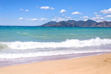 Mavi deniz ve kum izleri olan gün ışığı güneşli görünümünden su