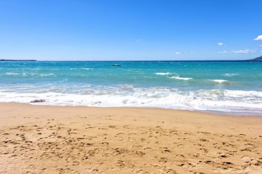 Mavi deniz ve kum izleri olan gün ışığı güneşli görünümüne