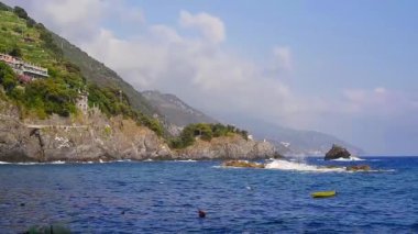 Mavi deniz ve dağlar Monterosso al Mare, Cinque Terre, İtalya, güneşli bir gün, kayalar üzerine çökmesini su asma teraslı