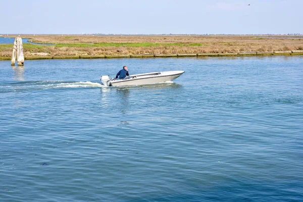 Vista de la luz del día a un hombre navegando en barco motorizado en Venecia Lago —  Fotos de Stock