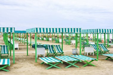 Canlı yeşil şezlong ve şemsiye gün ışığı görünümüne sahilde