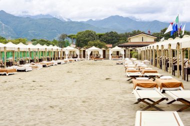 Sahilde bej şezlong ve şemsiye için gün ışığından yararlanma görünümü