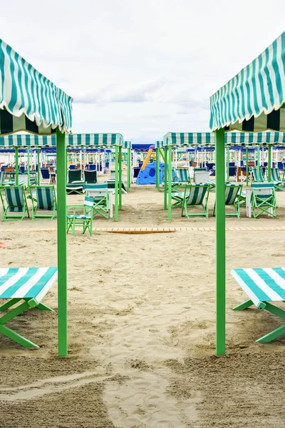 Nyári megtekintése a vibráló zöld sunchairs és napernyők a strandon — Stock Fotó