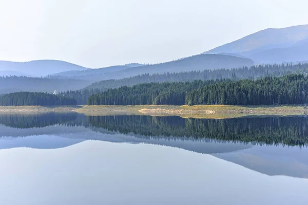 De mistige uitzicht daglicht naar Oasa dam lake met bergen — Stockfoto