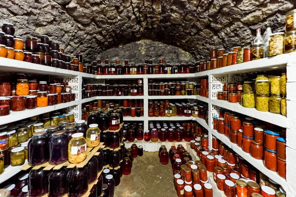 Cave tradicional cheia de garrafas de comida nas prateleiras — Fotografia de Stock