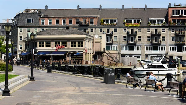 Ein Mehrfamilienhaus in der Nähe eines Sees, auf dem Yachten schwimmen — Stockfoto