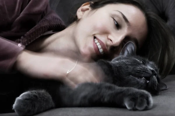 Mujer acostada en la cama con negro británico — Foto de Stock