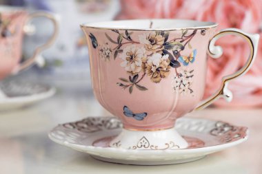 Çiçekli süs ve badem kurabiyeli pembe çay fincanları.