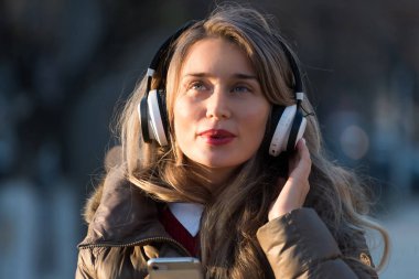 Telsiz kulaklıkla müzik dinleyen mutlu bir kadın.