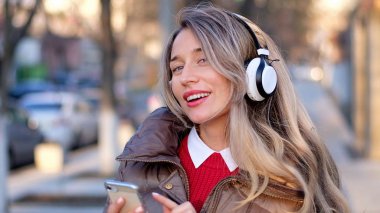 Telsiz kulaklıkla müzik dinleyen mutlu bir kadın.