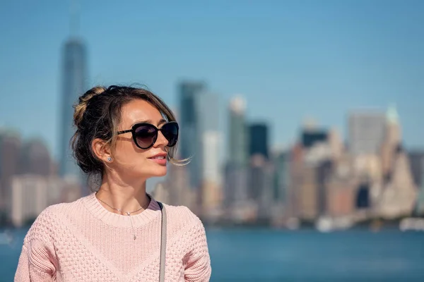 Donna in maglione rosa posa sullo sfondo della città di New York — Foto Stock