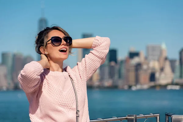 Donna in maglione rosa posa sullo sfondo della città di New York — Foto Stock