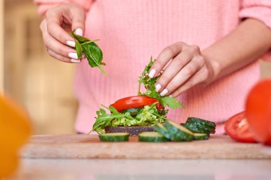 Kadın elleri sağlıklı sandviç yapıyor.