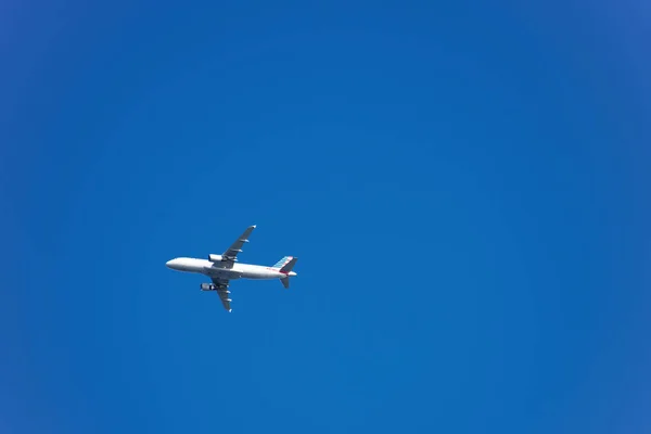 Um avião voando contra o fundo do céu limpo — Fotografia de Stock