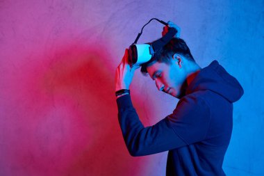 Genç adam sanal gerçeklik kaskı kullanıyor.