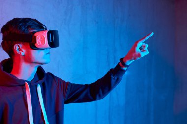 Genç adam sanal gerçeklik kaskı kullanıyor.