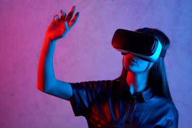 Ceket giyerken sanal gerçeklik kaskı kullanan genç bir kız.