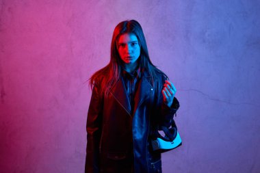 Ceket giyerken sanal gerçeklik kaskı tutan genç bir kız.