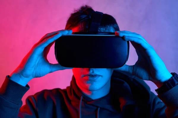Młody człowiek w kasku wirtualnej rzeczywistości patrząc w kamerę — Zdjęcie stockowe