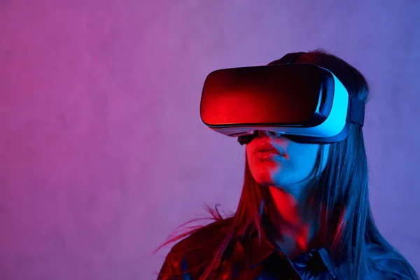 Ung flicka med hjälp av virtuell verklighet hjälm när du bär en jacka — Stockfoto
