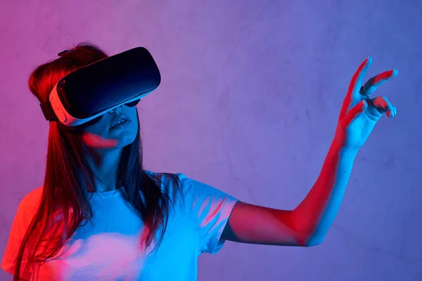 Młoda dziewczyna trzyma kask wirtualnej rzeczywistości w białym t-shircie — Zdjęcie stockowe