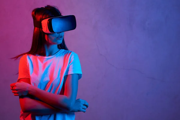 Ung flicka håller virtuell verklighet hjälm medan du bär en vit t-shirt — Stockfoto