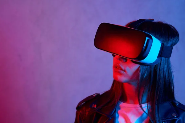 Ung flicka med hjälp av virtuell verklighet hjälm när du bär en jacka — Stockfoto